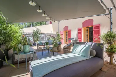 a bed on a patio with potted plants at Cosy Loft tarif avec 1 ou 2 chambres 2 ou 4 personnes, vue parc et piscine in Aix-en-Provence