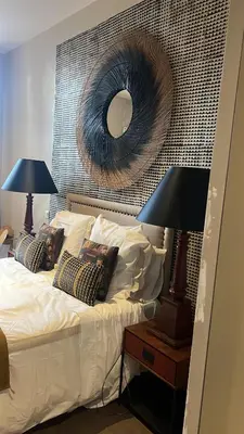 a bedroom with a bed with a mirror on the wall at Cosy Loft tarif avec 1 ou 2 chambres 2 ou 4 personnes, vue parc et piscine in Aix-en-Provence