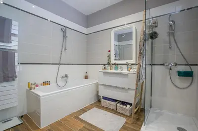 a bathroom with a tub and a sink and a shower at Cosy Loft tarif avec 1 ou 2 chambres 2 ou 4 personnes, vue parc et piscine in Aix-en-Provence