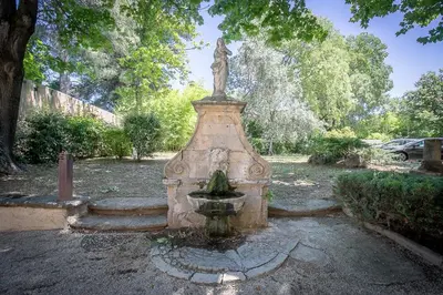 a statue of a woman sitting on top of a fountain at Cosy Loft tarif avec 1 ou 2 chambres 2 ou 4 personnes, vue parc et piscine in Aix-en-Provence
