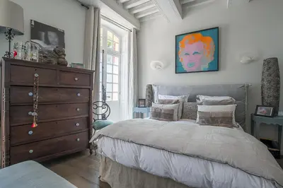 a bedroom with a large bed and a dresser at Cosy Loft tarif avec 1 ou 2 chambres 2 ou 4 personnes, vue parc et piscine in Aix-en-Provence