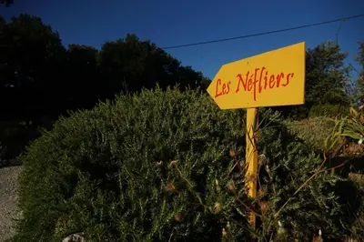 a yellow sign in front of a bush at Les Néfliers Gîte in Céreste