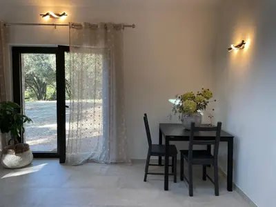a dining room with a table and chairs and a window at Les Néfliers Gîte in Céreste