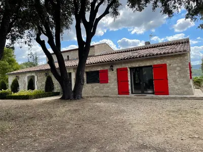 a house with red doors and a tree at Les Néfliers Gîte in Céreste