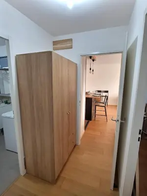 a large wooden door in a living room with a table at Vaste appartement avec terrasse, parking, proche Parc Expo Avignon in Avignon