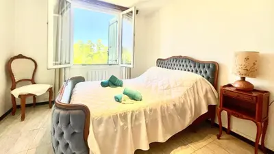 a bedroom with a bed with a chair and a window at Rendez-vous avec les cigales - gîte 6 personnes 100m2 - piscine privée - Climatisation in Cheval-Blanc