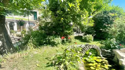 a garden with flowers and a tree and a house at Rendez-vous avec les cigales - gîte 6 personnes 100m2 - piscine privée - Climatisation in Cheval-Blanc