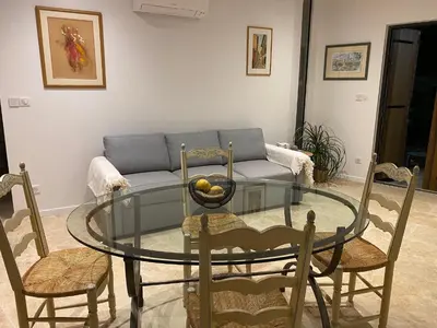 a living room with a glass table and a couch at Maison dans la pinède in Rognes