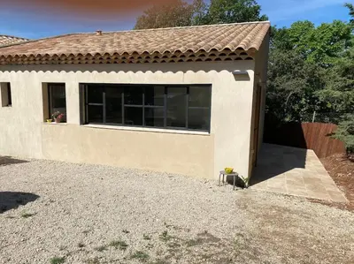 a small house with a large window at Maison dans la pinède in Rognes