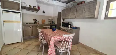 a kitchen with a table and chairs in a kitchen at La Carriera, petite maison Provençale sud Ventoux, climatisée in Bédoin