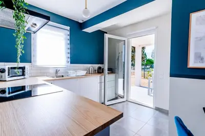 a kitchen with blue walls and a wooden counter top at ☆ Blue Provençal Appartement ☆ in Morières-lès-Avignon