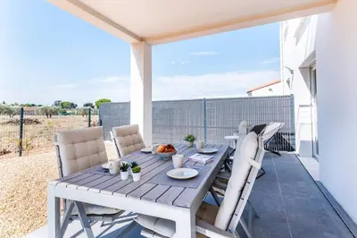 a dining table and chairs on a patio with a view of a field at ☆ Blue Provençal Appartement ☆ in Morières-lès-Avignon