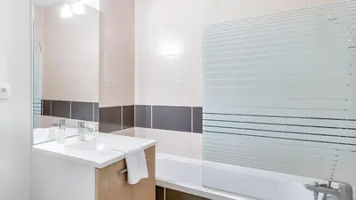 a white bathroom with a sink and a shower at Maison confortable Saint-Saturnin in Saint-Saturnin-lès-Avignon