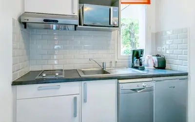 a white kitchen with a sink and a stove at Maison confortable Saint-Saturnin in Saint-Saturnin-lès-Avignon