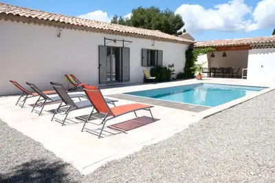 a villa with a swimming pool in front of a house at charming vacation rental with heated pool at the foot of the alpilles, in aureille, close to the center of the village on foot, sleeps 6/8 people in provence. in Aureille