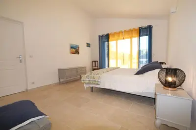 a bedroom with a bed and a large window at charming vacation rental with heated pool at the foot of the alpilles, in aureille, close to the center of the village on foot, sleeps 6/8 people in provence. in Aureille