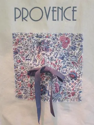 a book with a flower pattern on a wall at LE SOLEIL DU LUBERON - T2 avec Terrasse, Parking et Clim in LʼIsle-sur-la-Sorgue