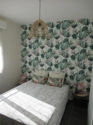 a bedroom with a large bed with a wallpaper at LE SOLEIL DU LUBERON - T2 avec Terrasse, Parking et Clim in LʼIsle-sur-la-Sorgue