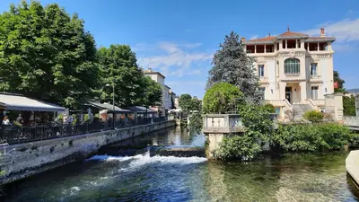 a bridge over a river in a city at Les Amandiers - L'Isle d'Or in LʼIsle-sur-la-Sorgue