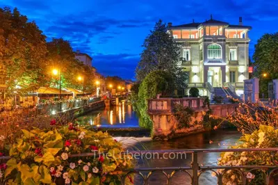 a view of a canal at night at Appartement à L'Isle-sur-la-Sorgue avec vue sur la ville in LʼIsle-sur-la-Sorgue