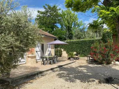 a patio with a table and an umbrella at Les Célestins - Villa en Provence in Carpentras