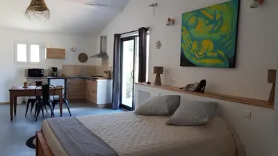 a bedroom with a bed and a kitchen with a table at le moulin in Crillon-le-Brave
