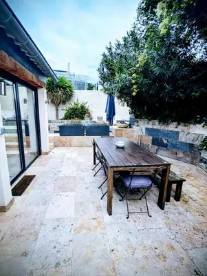 a wooden table and chairs on a patio at Maison avec piscine, jacuzzi et sauna privatifs - Mas de Nebbas in Aix-en-Provence
