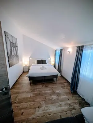 a bedroom with a bed and a wooden floor at Maison avec piscine, jacuzzi et sauna privatifs - Mas de Nebbas in Aix-en-Provence