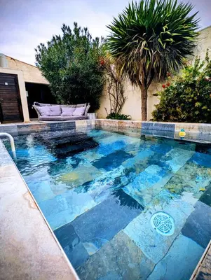 a swimming pool with blue water in a yard at Maison avec piscine, jacuzzi et sauna privatifs - Mas de Nebbas in Aix-en-Provence