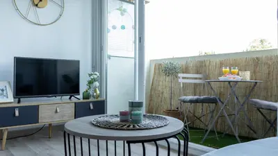 a living room with a tv and a table at Studio cosy à proximité du centre ville in Aix-en-Provence
