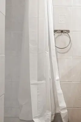 a shower with a white shower curtain in a bathroom at Studio cosy à proximité du centre ville in Aix-en-Provence