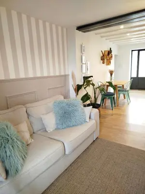 a living room with a white couch with blue pillows at A l'Ombre de la Dame in Cucuron