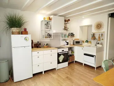 a kitchen with white cabinets and a white refrigerator at A l'Ombre de la Dame in Cucuron