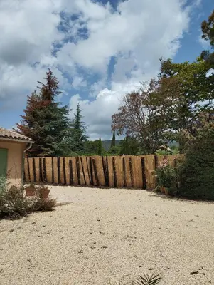 a wooden fence in front of a yard at Les Chêneslierres in Lourmarin