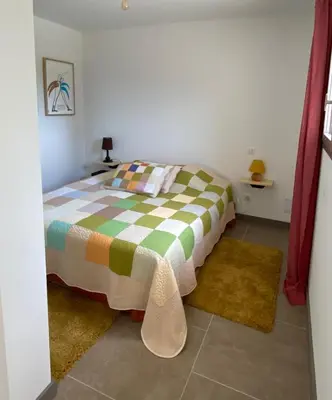 a bedroom with a bed and two rugs at Les Chêneslierres in Lourmarin