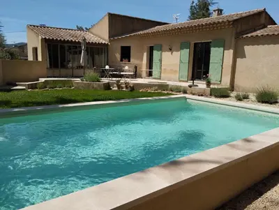 a swimming pool in front of a house at Les Chêneslierres in Lourmarin
