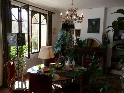 a dining room with a table with a lamp and plants at Lou Amourie in Roussillon