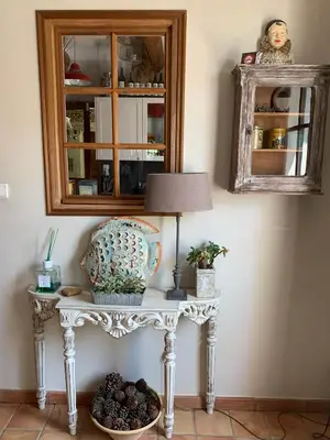 a table with a lamp and a mirror at Le Jardin sur la colline près du Golf in LʼIsle-sur-la-Sorgue