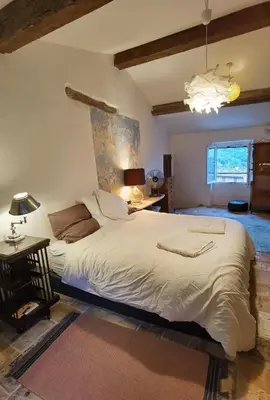 a bedroom with a large bed and a chandelier at Romantic Provencal house with terrace in Saignon