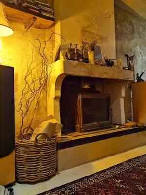 a living room with a fireplace with a tv at Romantic Provencal house with terrace in Saignon