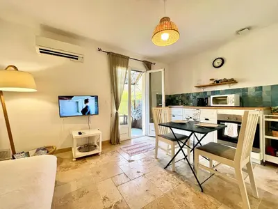 a living room with a table and a kitchen at Lou Maestoso - Cosy, Campagne, CLIM, 2 personnes in Lançon-Provence