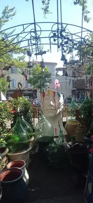 a group of glass vases sitting in a garden at L'IRIS D OR - 3 Étoiles- 3ème étage in LʼIsle-sur-la-Sorgue