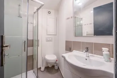 a white bathroom with a sink and a toilet at L'IRIS D OR - 3 Étoiles- 3ème étage in LʼIsle-sur-la-Sorgue