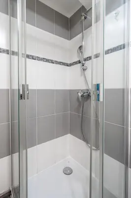 a shower with a glass door in a bathroom at L'IRIS D OR - 3 Étoiles- 3ème étage in LʼIsle-sur-la-Sorgue