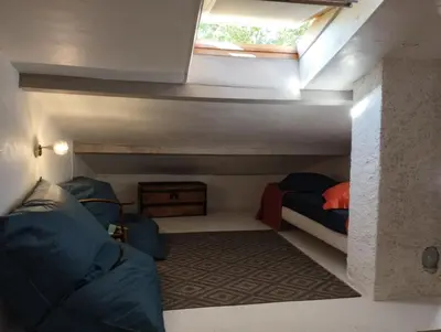 a small room with two beds and a window at Chambre d’hôtes l’Orange Bleue in Rustrel