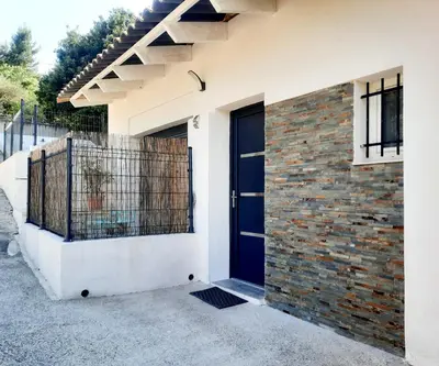 a house with a blue door and a brick wall at Adorable petite maison au coeur du Luberon in Villelaure