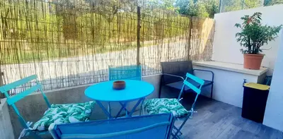 a blue table and chairs on a balcony with a window at Adorable petite maison au coeur du Luberon in Villelaure