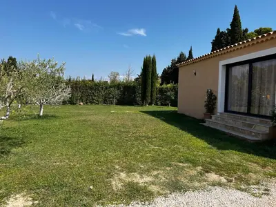 a backyard of a house with a grass yard at Magnifique maisonnette Dépendance avec Piscine in Châteaurenard