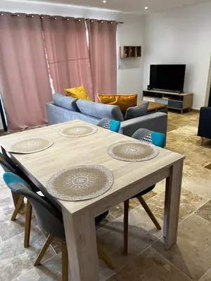 a living room with a table and a couch at Magnifique maisonnette Dépendance avec Piscine in Châteaurenard