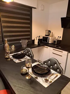 a kitchen with a table with plates and wine glasses at L'Aurore Love Room de prestige jacuzzi sauna piscine chauffée cuisine in Carpentras